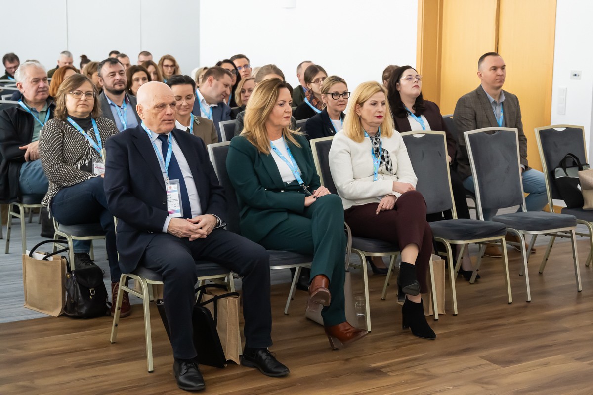 zdjęcie przedstawia salę w której odbywała się konferencja, widoczne są osoby uczestniczące w konferencji
