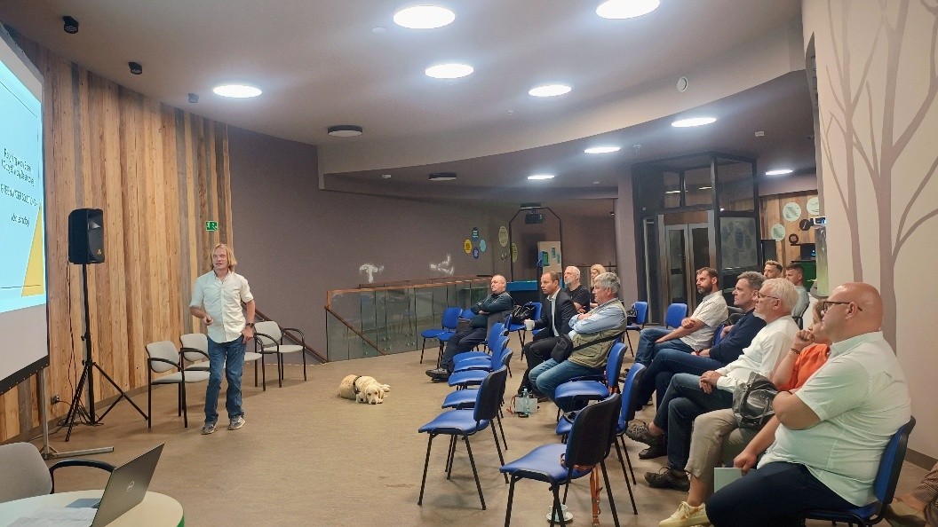 zdjęcie przedstawia osoby słuchające wykładu