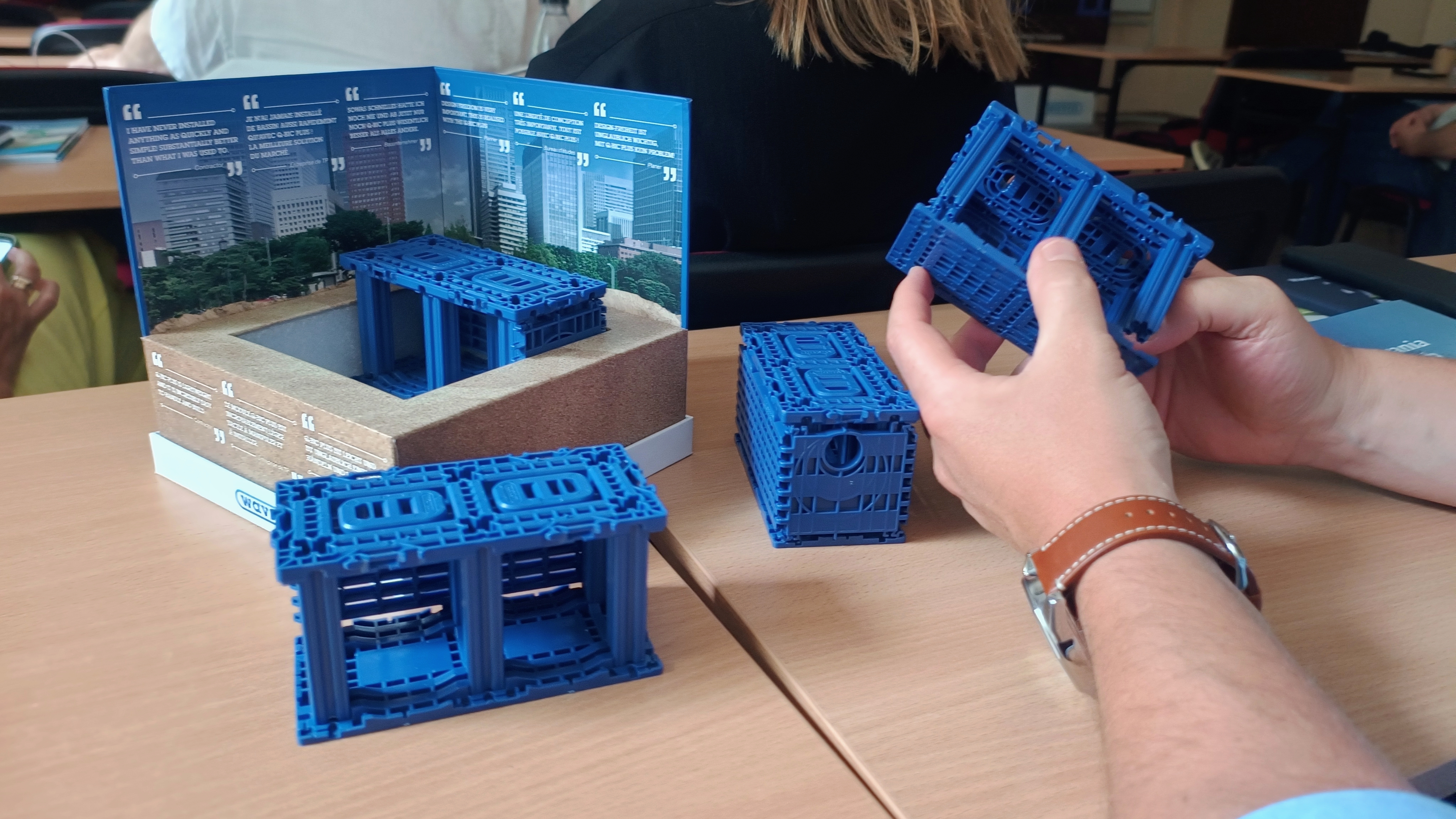 miniatury elementów do budowy systemów retencji wodnej trzymane w dłoniach przez uczestnika warsztatów